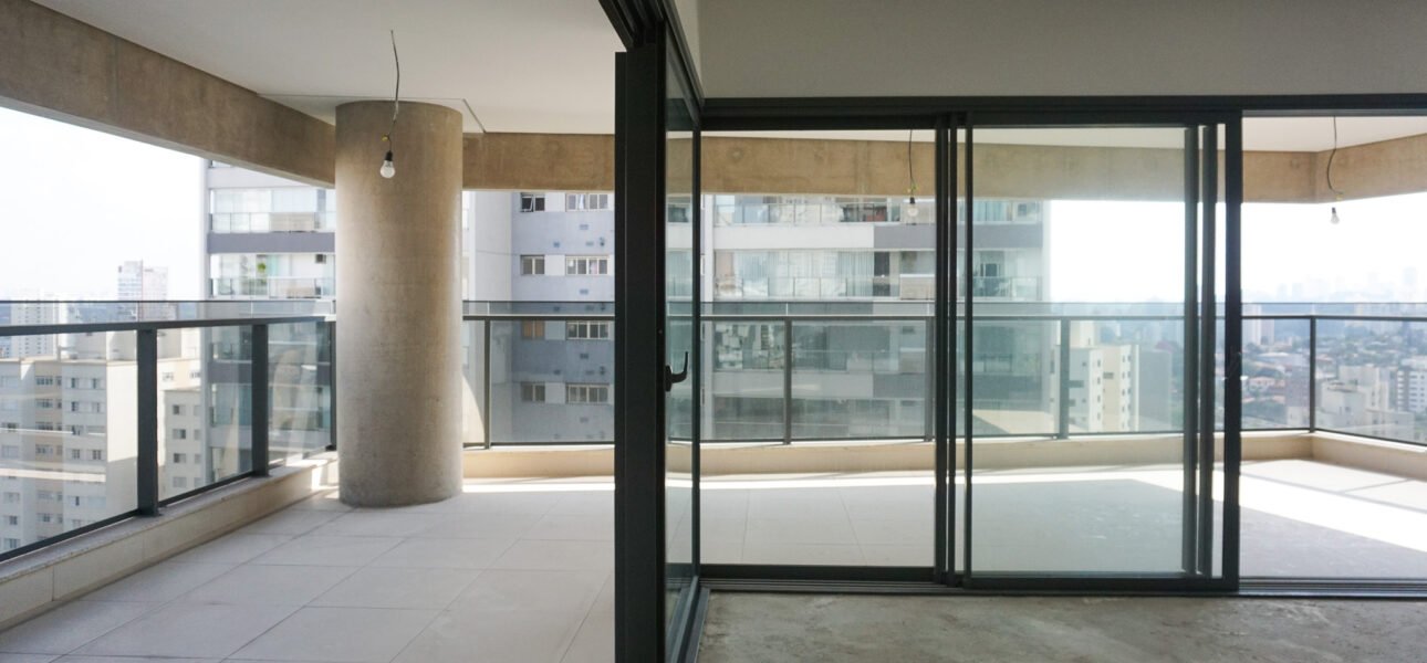 Sala de estar espaçosa com iluminação natural e integração com varanda em “L”.